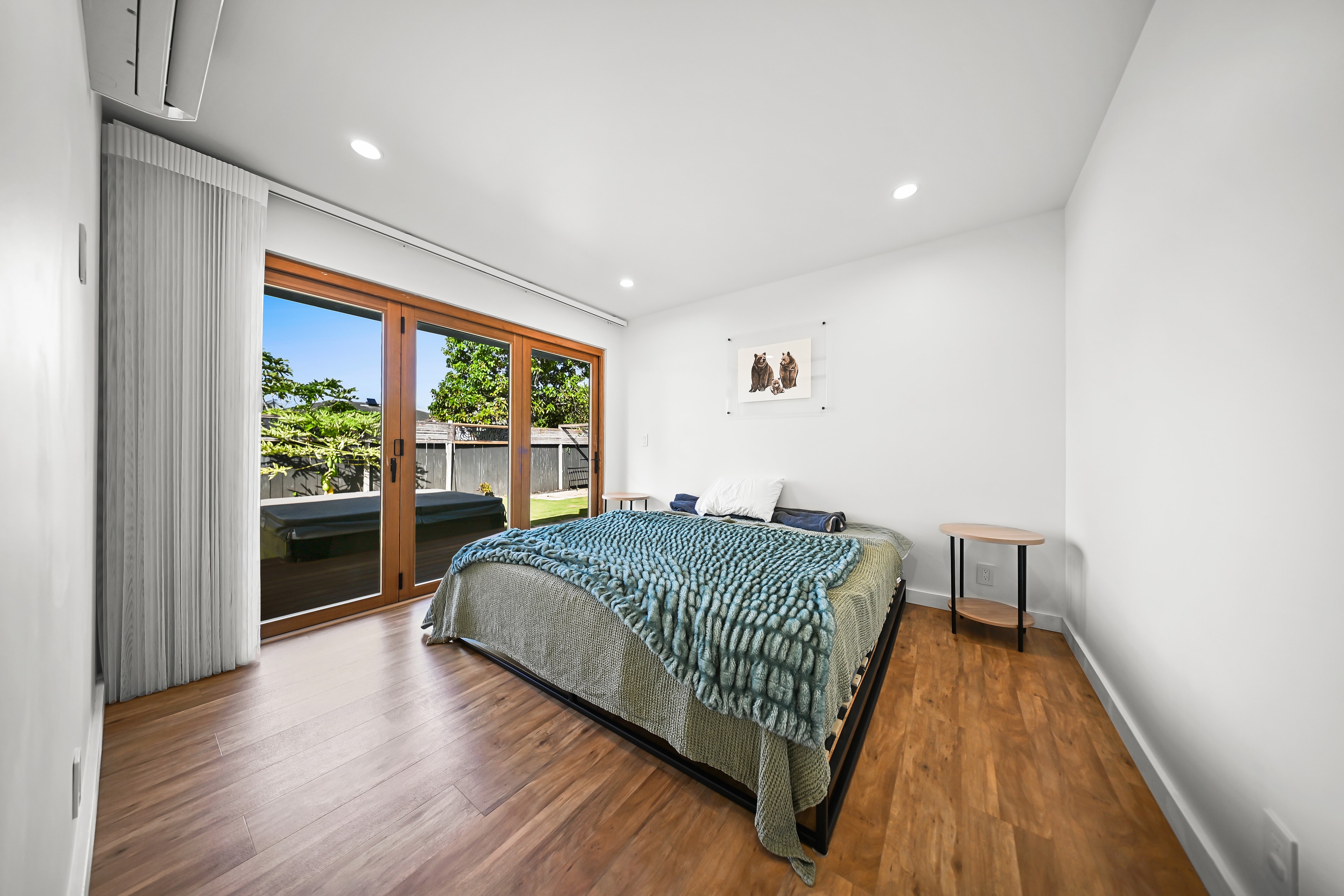Primary bedroom with wood floors, sliding glass doors, and direct backyard access