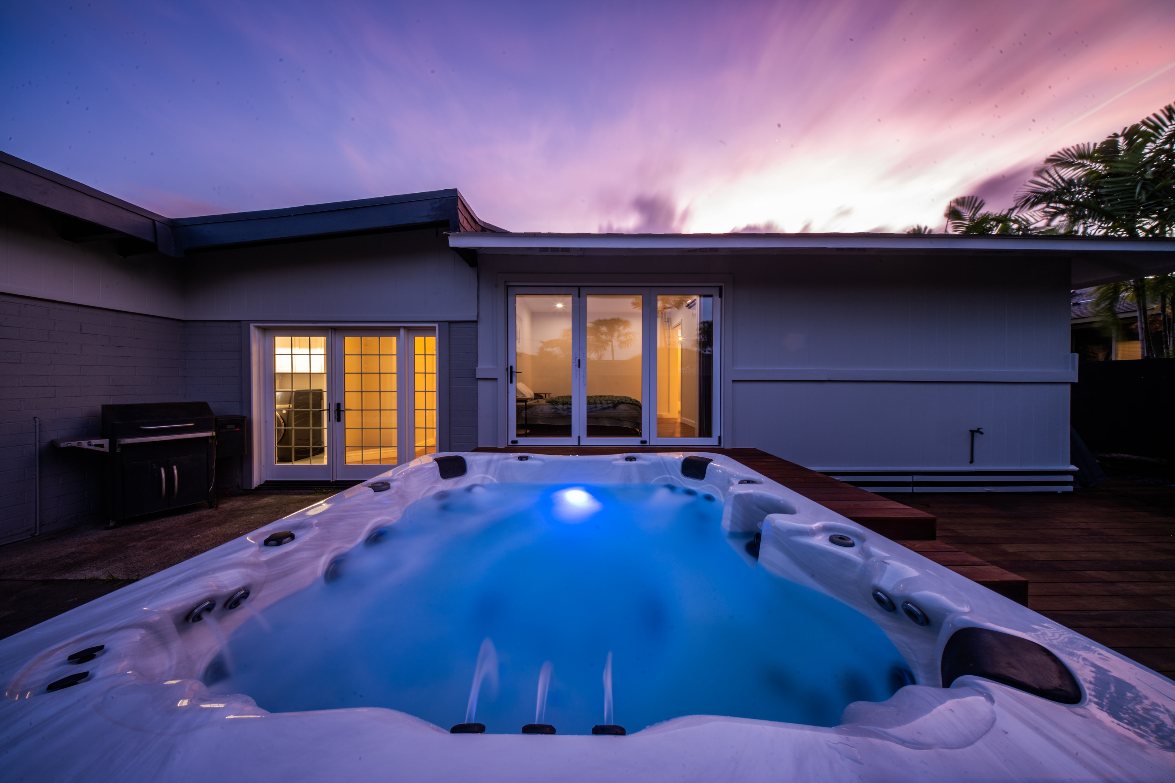 Hot tub close-up at dusk, glowing blue with purple sky